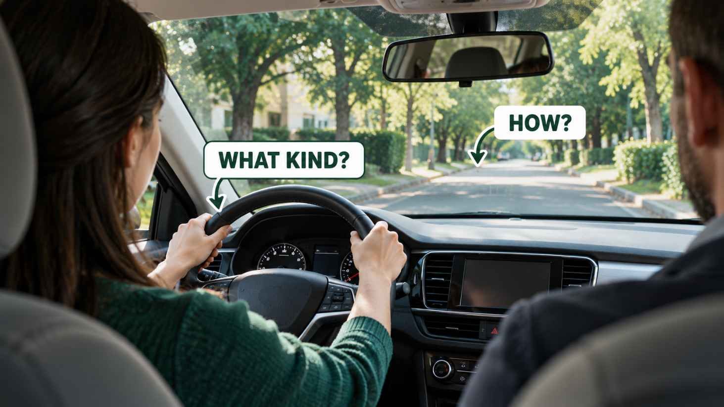 View from the back seat of a driving lesson car with a learner's hands on the wheel and two labels reading WHAT KIND and HOW.