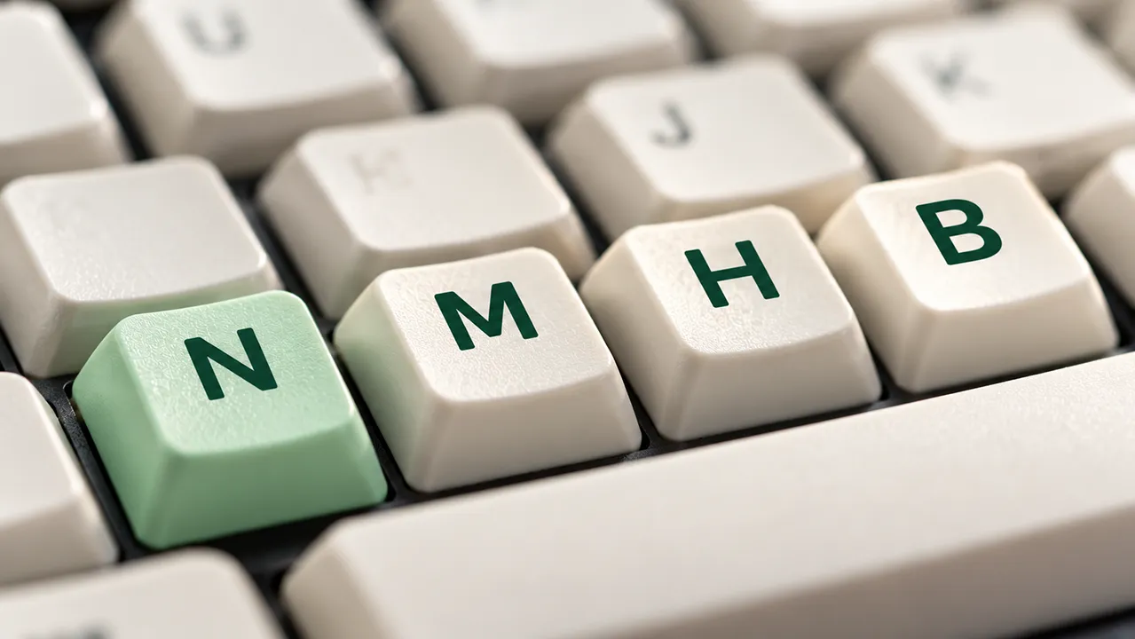 Macro shot of keyboard keys N, M, H, and B with the N key tinted mint green